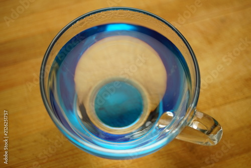 transparent blue glass of water on a wooden table.