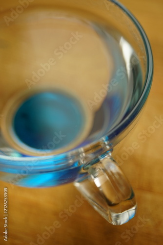 blue transparent glass of water on a wooden table.