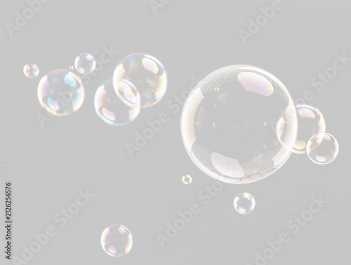 Cluster of iridescent soap bubbles floating against a dark background with colorful reflections on transparent background