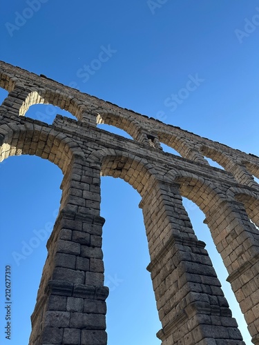 Foto Low angle view of ancient Roman Aqueduct of Segovia stone arches against clear b