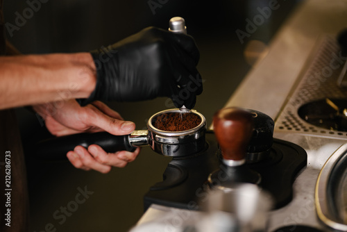 Fotografie Professional Barista Preparing Fresh Espresso Using Portafilter in Modern Coffee