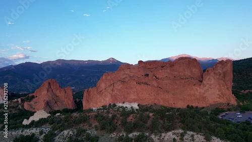 Aerial view of big orange rock face in front of mountains