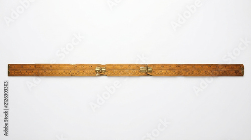 Vintage wooden folding ruler with brass hinges, antique carpenter's measuring tool, isolated on white background