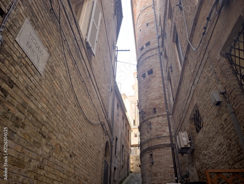 Fotografía Vicolo stretto tra edifici in mattoni chiari, con insegna “Vicolo Bonarelli”,