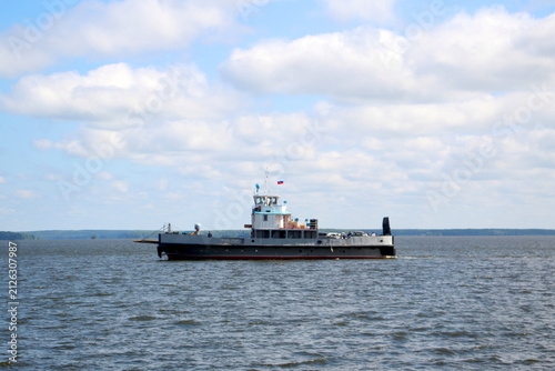 Foto A small ship sails along a big river.