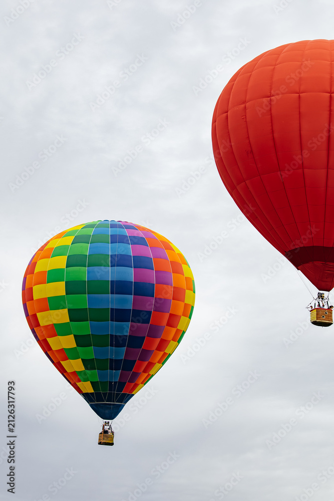 Obraz premium Colorful hot air balloons flying in cloudy sky during festival, outdoor adventure travel background.