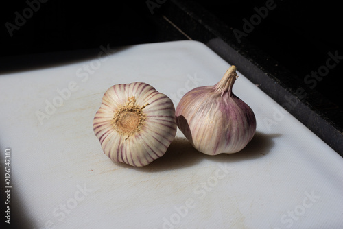 Pair of whole garlic bulbs on white surface