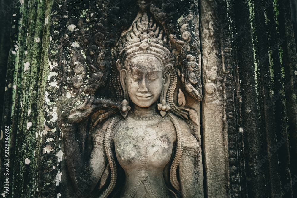 Fototapeta premium Ancient stone carving of a female Apsara dancer inside Angkor Wat temple in Siem Reap, Cambodia