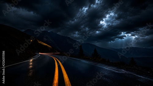 Wet winding asphalt road with double yellow lines under dark stormy sky