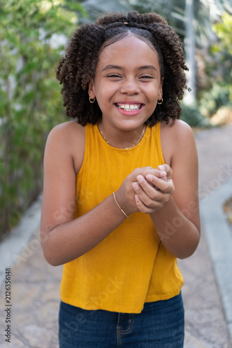 Happy teen girl laughing outdoors, showing joy