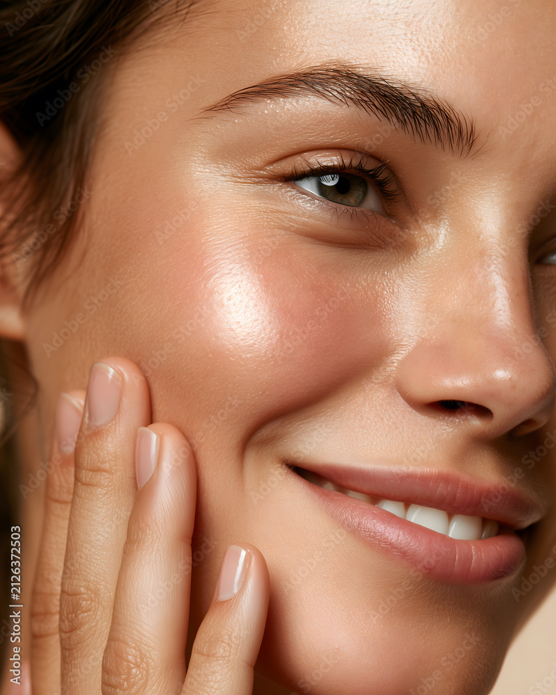Obraz premium Woman touching her glowing hydrated cheek with fingertips after HydraFacial treatment