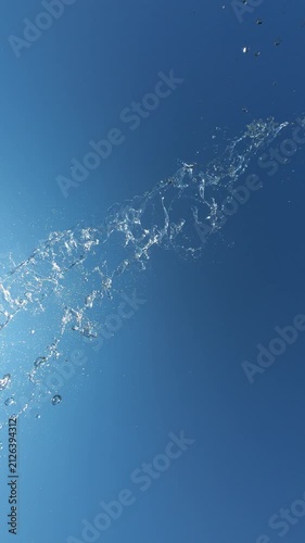 Water Splash Spraying Towards Camera Against Blue Clear Sky in Slow Motion