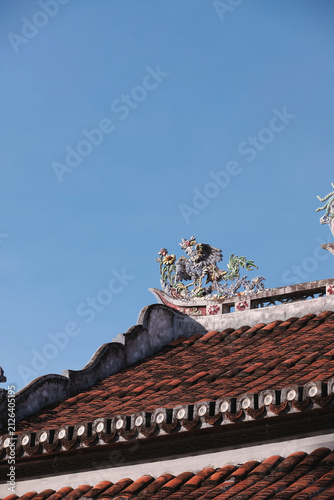 Принти на полотні Traditional Asian temple architecture featuring inlaid ceramic bird sculpture on roof tiles in Hoi An