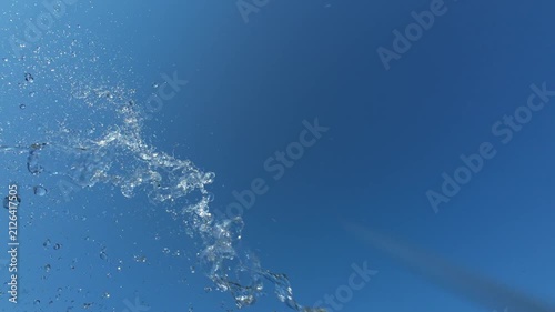 Fresh Water Splash Bursting From Left Side Against Bright Blue Sky