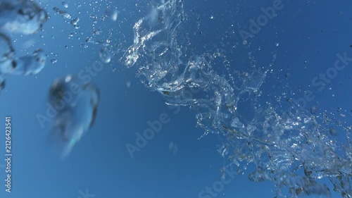 Water Splash Spraying From Above Against Clear Blue Sky with Birds in Background