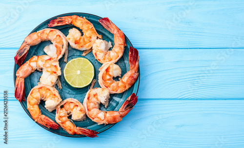 Obraz na płótnie Grilled shrimp platter with fresh lime on blue wooden background
