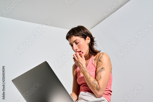 Hesitant woman working on her laptop