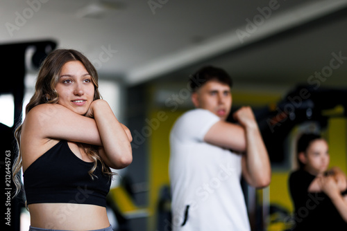 Fotografie Group of individuals stretching in a gym during a workout session in the morning