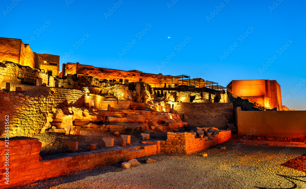 Fototapeta premium The ancient ruins of At-Turaif historical site illuminated at night under a clear blue sky in Diriyah, Saudi Arabia.