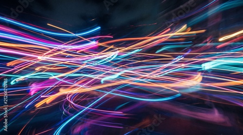 Abstract streaks of vibrant neon light trails in motion blur against a dark background