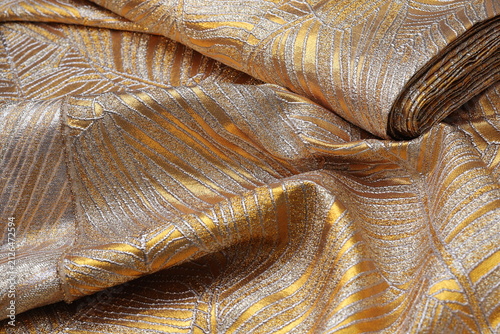 Quadro su tela Luxurious gold and silver brocade fashion fabric featuring an elegant wavy leaf pattern, showcasing rich metallic texture and shimmering folds for high-end couture design