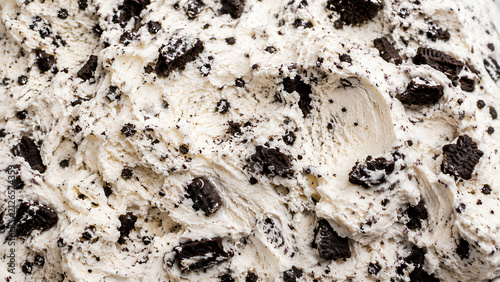 Close-up macro texture of creamy cookies and cream ice cream with abundant chocolate cookie chunks and crumbs. Perfect food background for menus, packaging and dessert advertising.