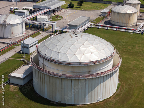 This aerial view shows a petroleum storage terminal featuring large fuel tanks and industrial facilities for oil distribution.
