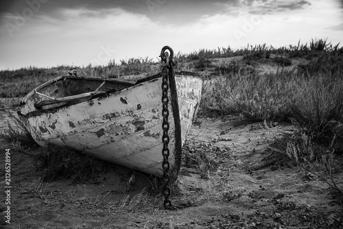 Canvastavla Moody beached vintage lifeboat with peeling paint and chain on the bow