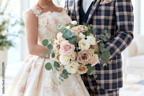 結婚式を祝う新郎新婦と美しいブーケの
