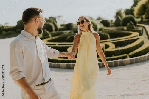 Couple enjoys a sunny stroll in a beautifully landscaped garden