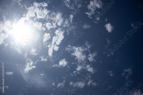 Fotografía Inquadratura dal basso del sole splendente nel cielo blu parzialmente coperto da