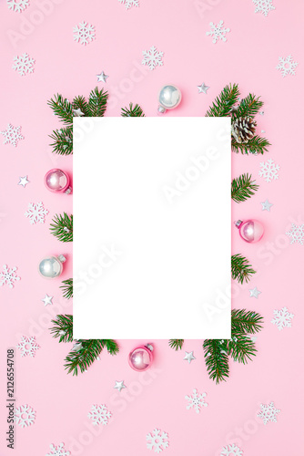 Christmas, New Year vertical frame of fir tree branches, Christmas baubles, decorations on pink and white flat lay background. Perfect for holiday greetings, banners, social media. Copy space