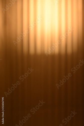 A dreamy view of a golden yellow light on the wall.