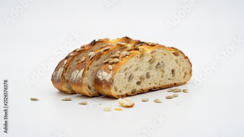 three slices of fresh sunflower seed sourdough bread on white surface