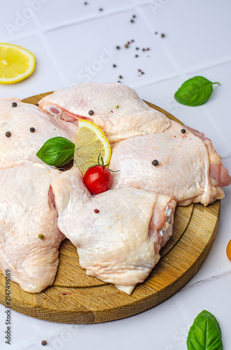 raw chicken thighs on a white background, raw chicken thighs on a wooden board