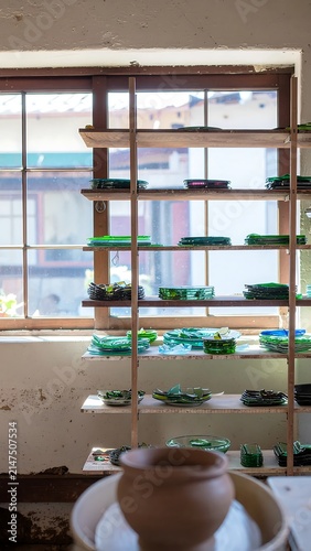 Modern office interior with green glass wall and plants.