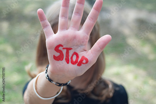 The concept of violence and child abuse. A little girl holds out her hand with the word 