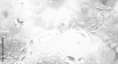 Monochrome wet glass with water droplets, soft blurred texture, bright central copy space, abstract background