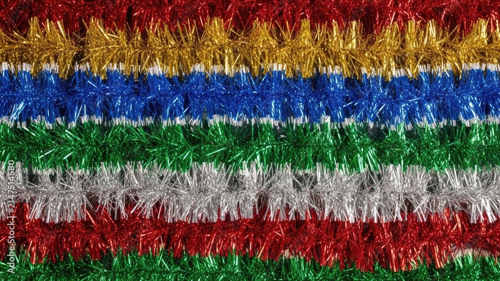 Obraz premium Colorful Christmas tinsel garlands in red, gold, blue, green, and silver stripes for festive holiday decoration