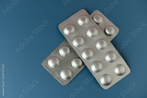 Obraz na płótnie Blister packs of tablets lay on a bright blue surface, offering a glimpse into the world of health and well-being