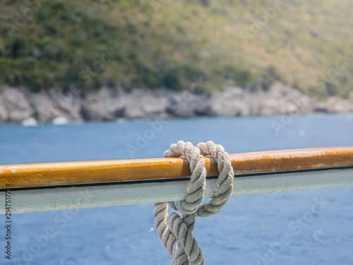 Bild auf Leinwand Ship Nautical Rope Knot Tied to Wooden Handrail