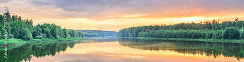 Golden sunset paints calm river's surface