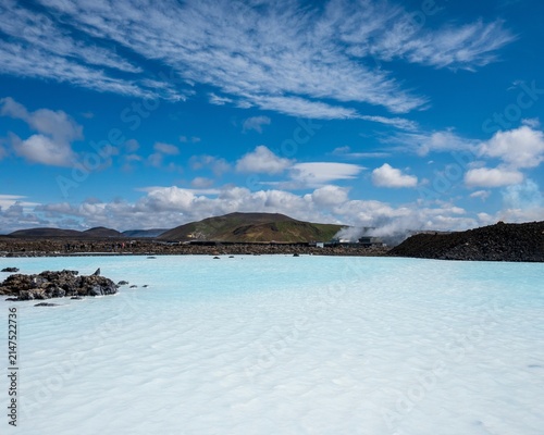 Bild auf Leinwand Turquoise geothermal lagoon beneath a bright blue sky, Iceland