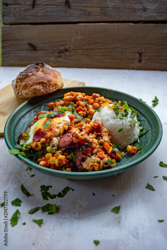 Canvas Print Mexican-style bowl with black beans, spicy chorizo sausage, roasted vegetables, fresh herbs, and rice