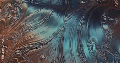 Abstract iridescent metallic liquid swirls with intricate patterns.