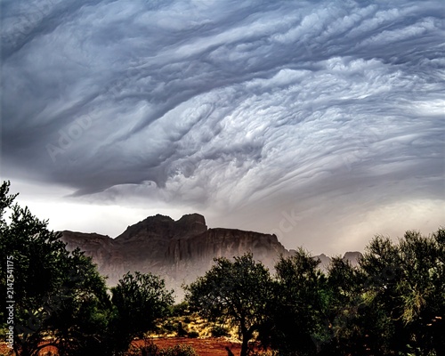 Powerful summer monsoon storm approaching the Superstition Mountains near Phoenix, Arizona, with dramatic swirling storm clouds, blowing rain and rugged desert scenery.