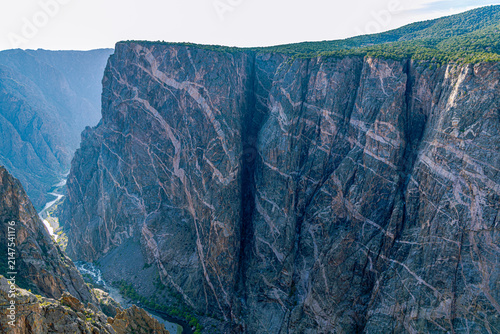 Light pegmatite veins streak the massive dark cliff face of the Painted Wall, Colorado's tallest cliff.
