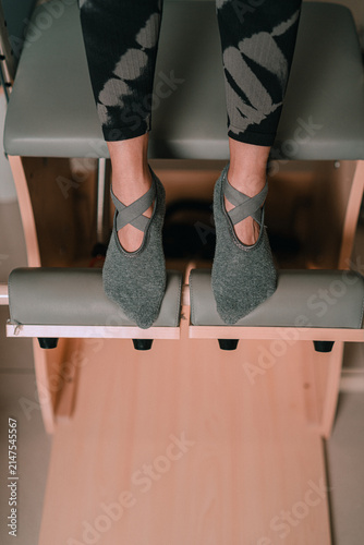 Feet on Pilates Chair Pedals in Modern Sport Studio Concept