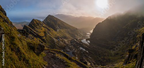 Konstfotografi Sunlight breaking through fog over Faha Ridge and glacial lakes on Mount Brandon