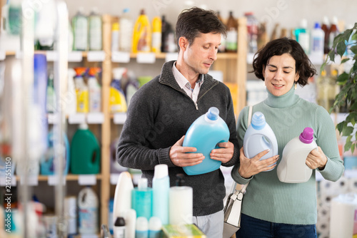 Fotografía Married couple chooses detergent in household goods department of the supermarke